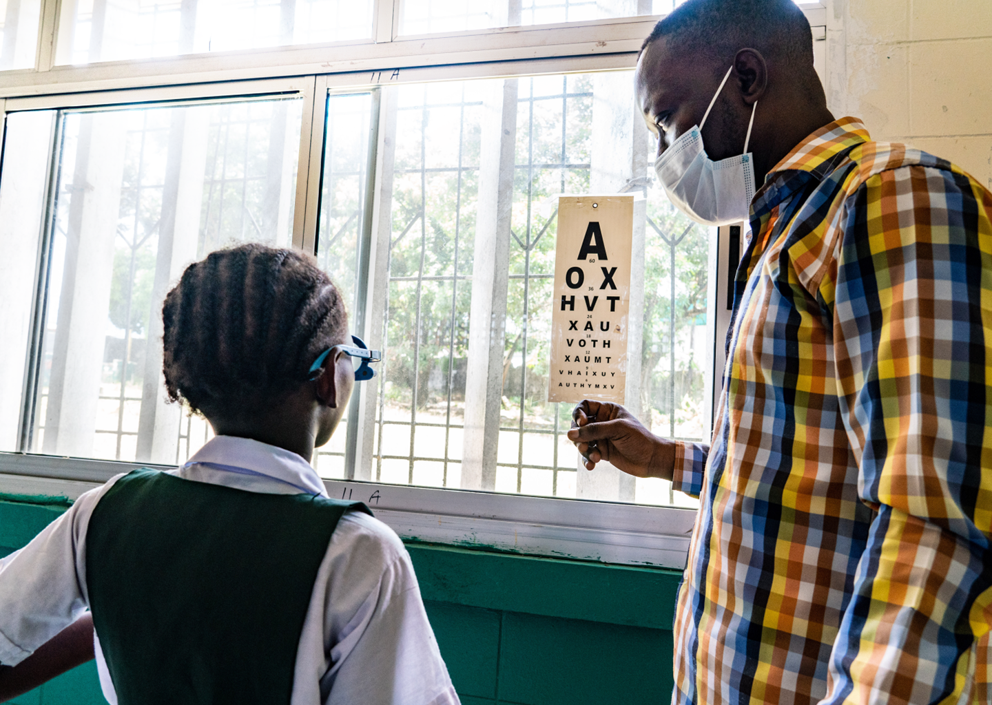 An eye care professional checking a child’s vision